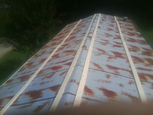 Rusted metal roof panels with new wood purlins before replacement — Storm Damage Roof Repair in Lyndon by Roofing Brothers